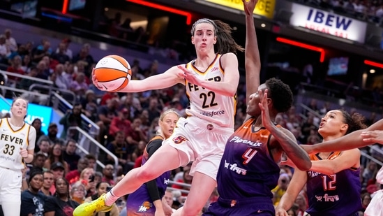 Latest entertainment news on July 14, 2024: Indiana Fever guard Caitlin Clark (22) makes a pass over Phoenix Mercury forward Natasha Mack (4) in the second half of a WNBA basketball game in Indianapolis, Friday, July 12, 2024. 