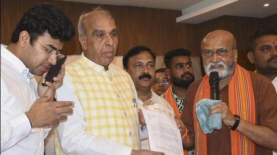Joint Committee of Parliament on the Waqf (Amendment) Bill Chairman Jagdambika Pal shows a petition that he received after a meeting with local farmers regarding their lands being claimed by the State Waqf Board, in Hubballi on Thursday. (PTI) Joint Committee of Parliament on the Waqf (Amendment) Bill Chairman Jagdambika Pal shows a petition that he received after a meeting with local farmers regarding their lands being claimed by the State Waqf Board, in Hubballi on Thursday. (PTI)