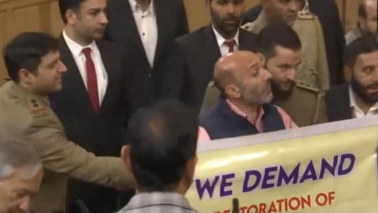 Jammu and Kashmir Awami Ittehad Party MLA Khurshid Ahmad Sheikh displaying a banner on Article 370 in J&K assembly.