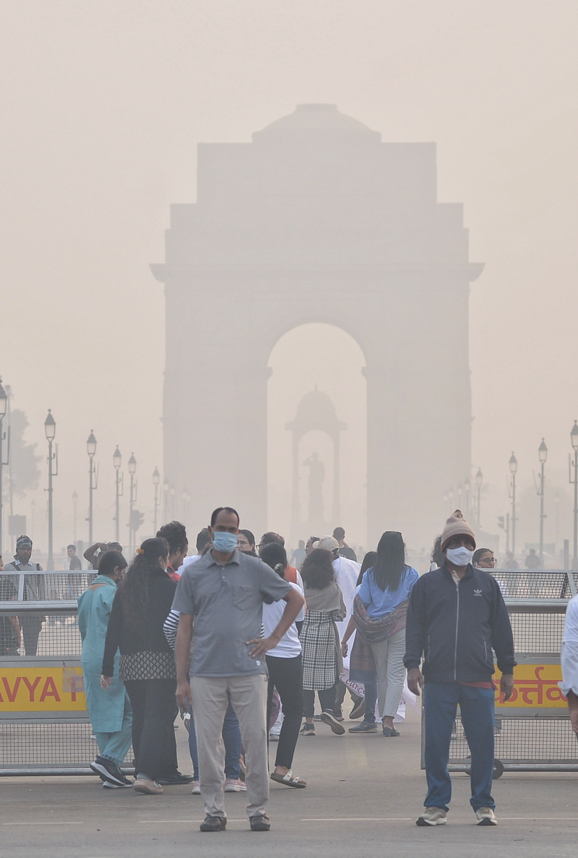 दिल्ली में रविवार सुबह प्रदूषण के बीच लोग मास्क लगाकर इंडिया गेट पहुंचे।
