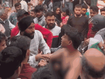 युवक के साथ मारपीट करता दुकानदार।