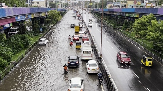 Vehicles ply on a waterlogged road following heavy rainfall triggered by Cyclone Fengal, in Chennai on Saturday. (ANI)(HT_PRINT)