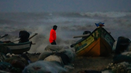 A visitor takes pictures as sea waves crash amid strong winds at the Marina beach, in Chennai, Saturday, Nov. 30, 2024. (PTI)