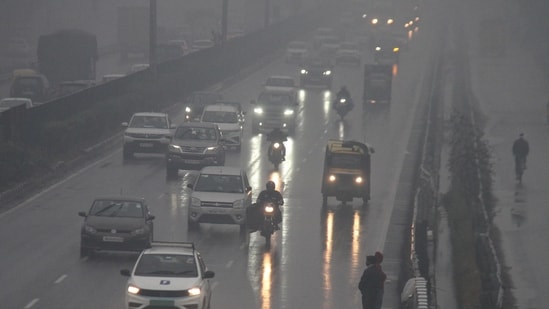 Vehicles ply on Delhi-Gurugram Expressway during rain on a cold winter day, in Gurugram on Friday. (ANI)