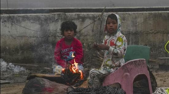 Children warm themselves near a bonfire as temperature dips in New Delhi. (PTI Photo) Children warm themselves near a bonfire as temperature dips in New Delhi. (PTI Photo)