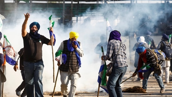 Farmers react as they try to get cover from tear gas, while they march towards New Delhi to press for better crop prices promised to them in 2021 at the Shambhu barrier, a border crossing between Punjab and Haryana. REUTERS(REUTERS)