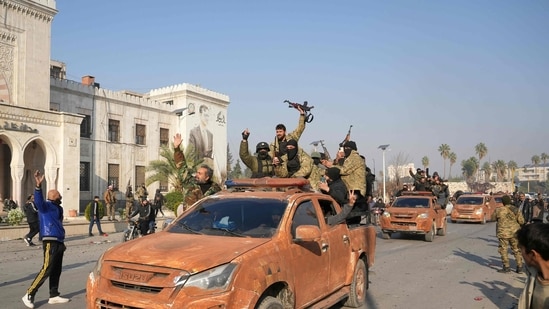 Latest news on December 7, 2024: Syrian anti government fighters celebrate as they pour into the captured central-west city of Hama on December 6, 2024.