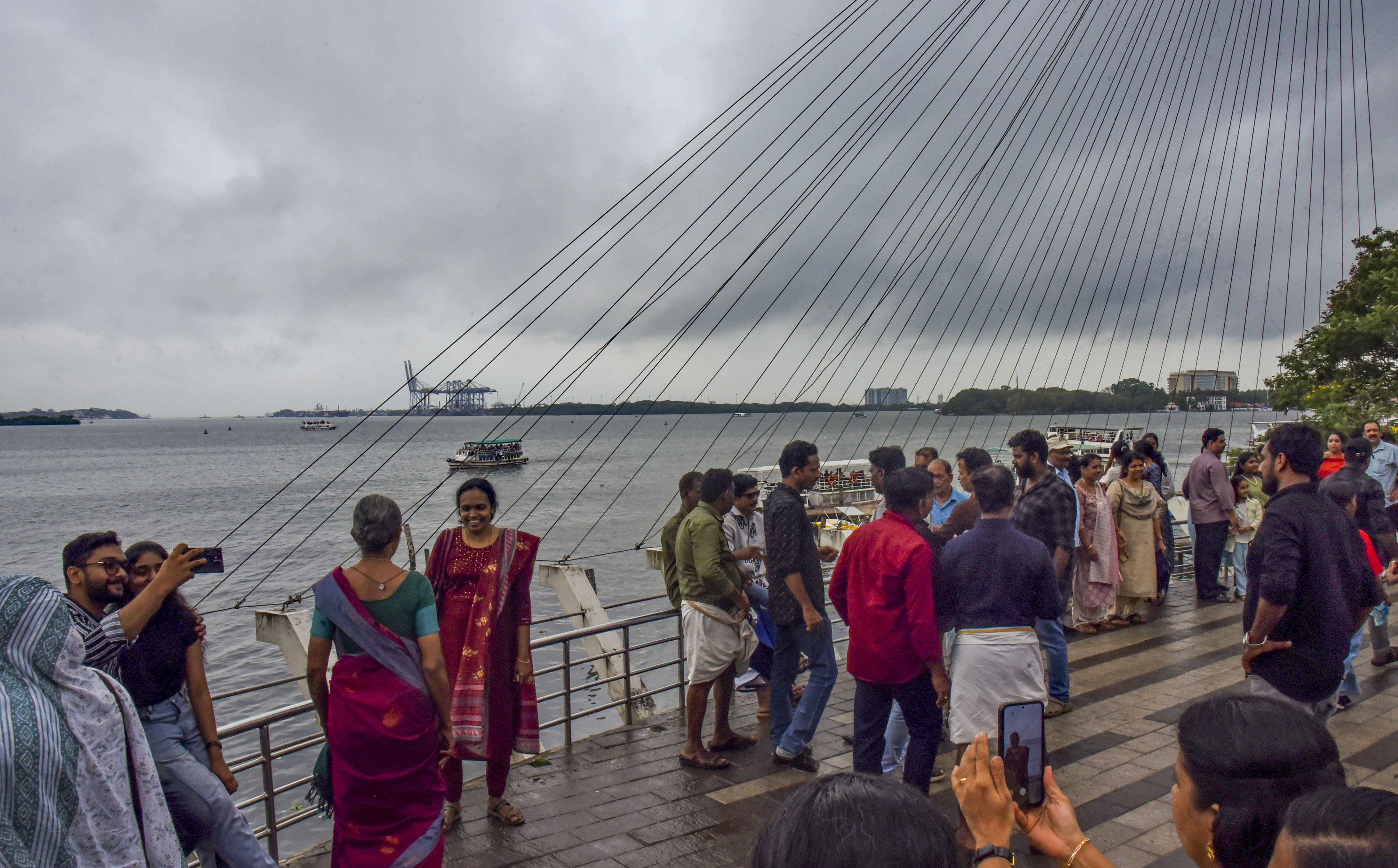 Visitors at Marine Drive as dark clouds cover the skyline, in Kochi, Kerala, Saturday after the southwest monsoon hit Kerala(PTI) Visitors at Marine Drive as dark clouds cover the skyline, in Kochi, Kerala, Saturday after the southwest monsoon hit Kerala(PTI)
