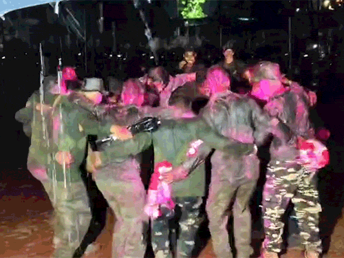 बारिश के बीच खुशी में रंग-गुलाल उड़ाकर थिरकते हुए जवान।