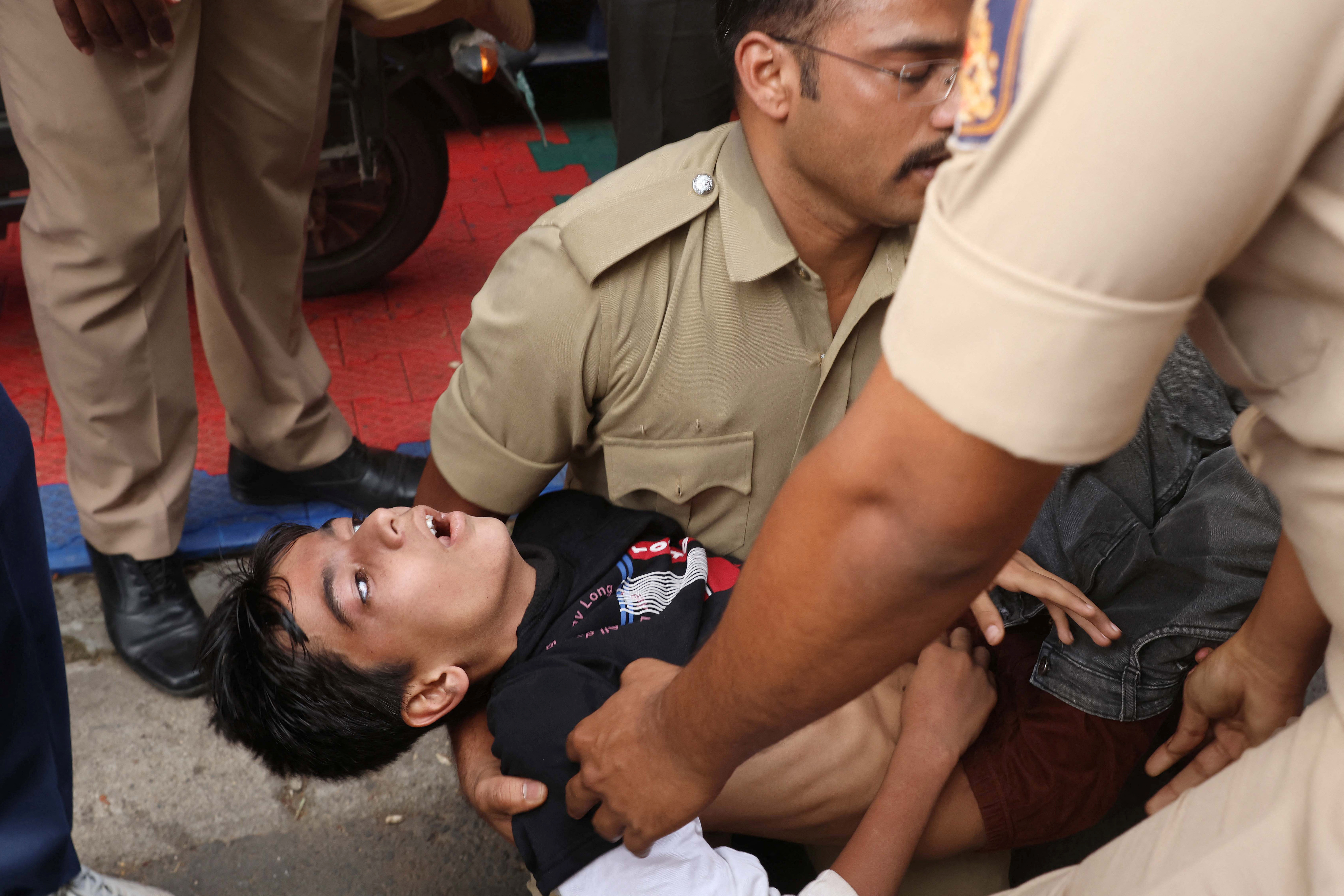 भगदड़ में बेहोश बच्चे को ले जाते पुलिस वाले।